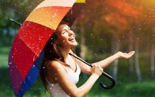 девушка с разноцветным зонтиком радуется дождю