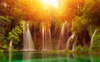 водопад в зеленом лесу на закате солнца