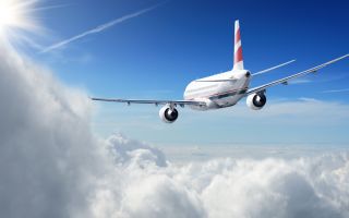 полет пассажирского самолета на высоте между облаками