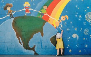 маленькая девочка возле большого рисунка на стене