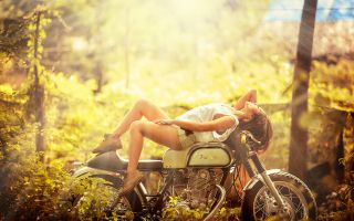 девушка лежит на мотоцикле